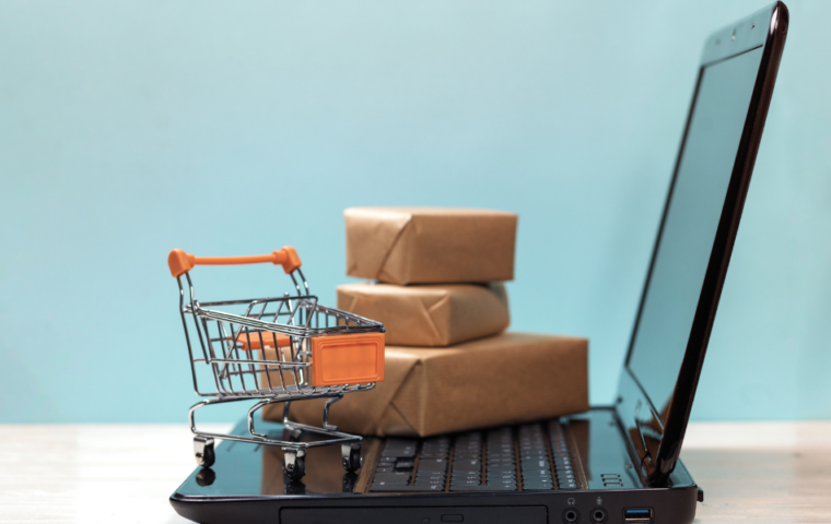 Laptop with miniature shopping card and brown packages