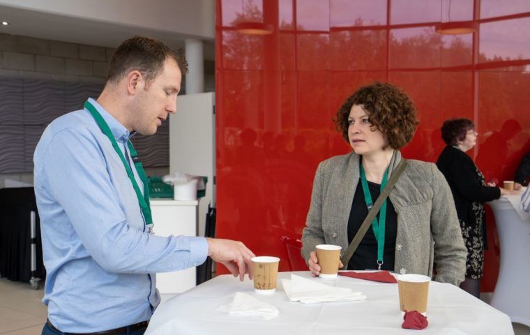 Two people talking over coffee at an event