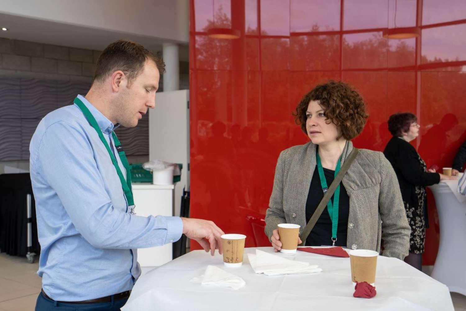 Two people talking over coffee at an event