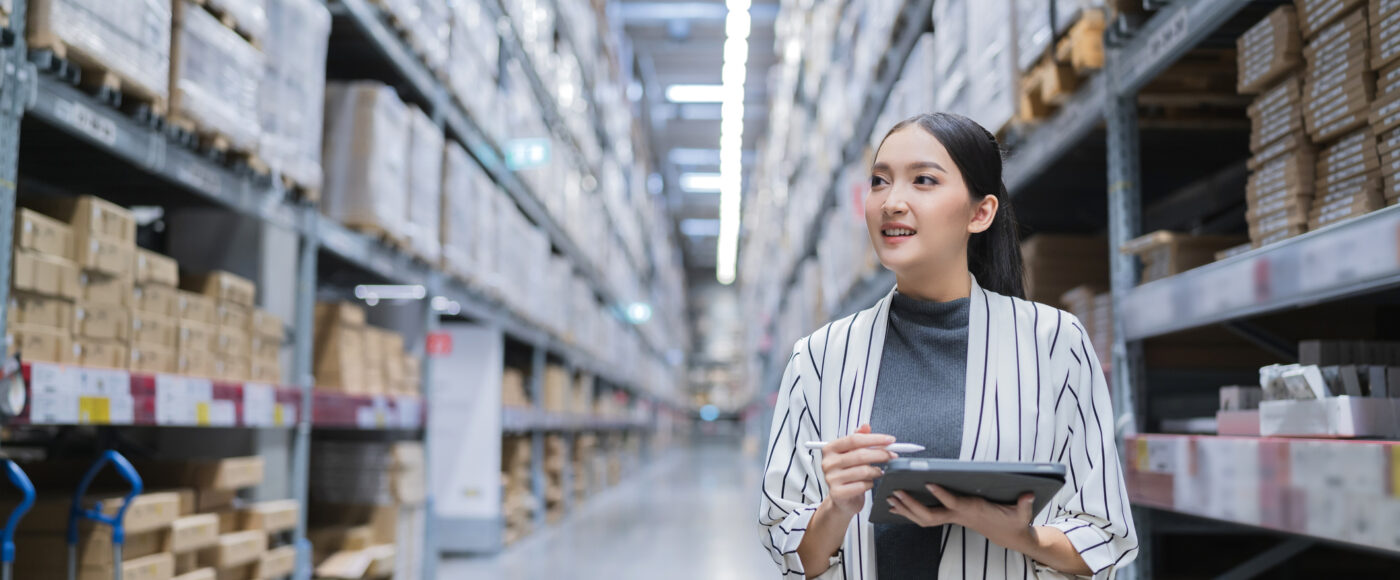 I Stock First Time Exporters smiling warehouse manager with list checking inventory