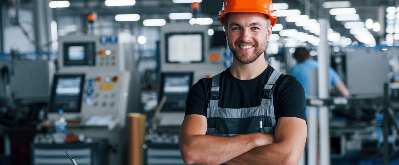 I Stock Synergy worker smiling wearing hardhat in advanced factory