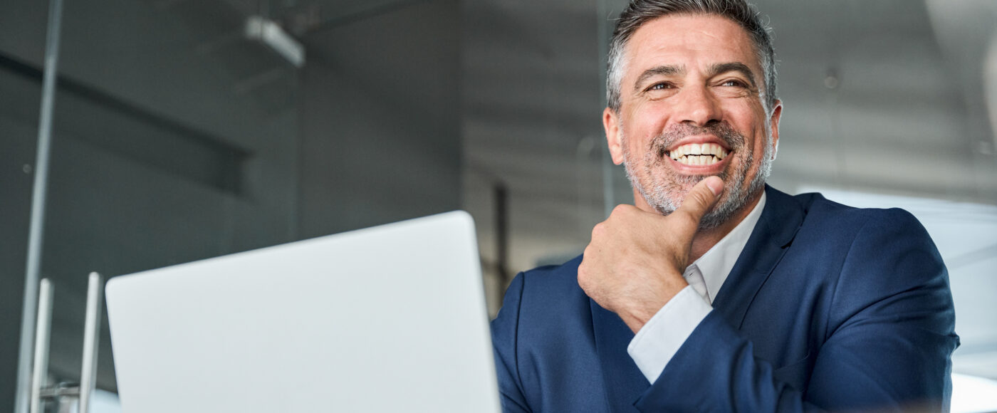 I Stock TEP Smiling business person with blue suit and laptop
