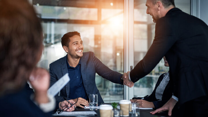 I Stock Trade Export Clinic 2 business people shaking hands smiling in meeting room