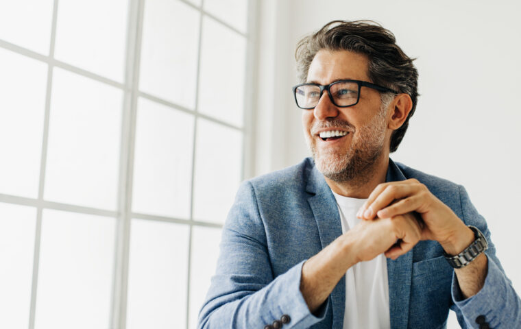 I Stock SEIS Smiling business profressional sitting with blue suit