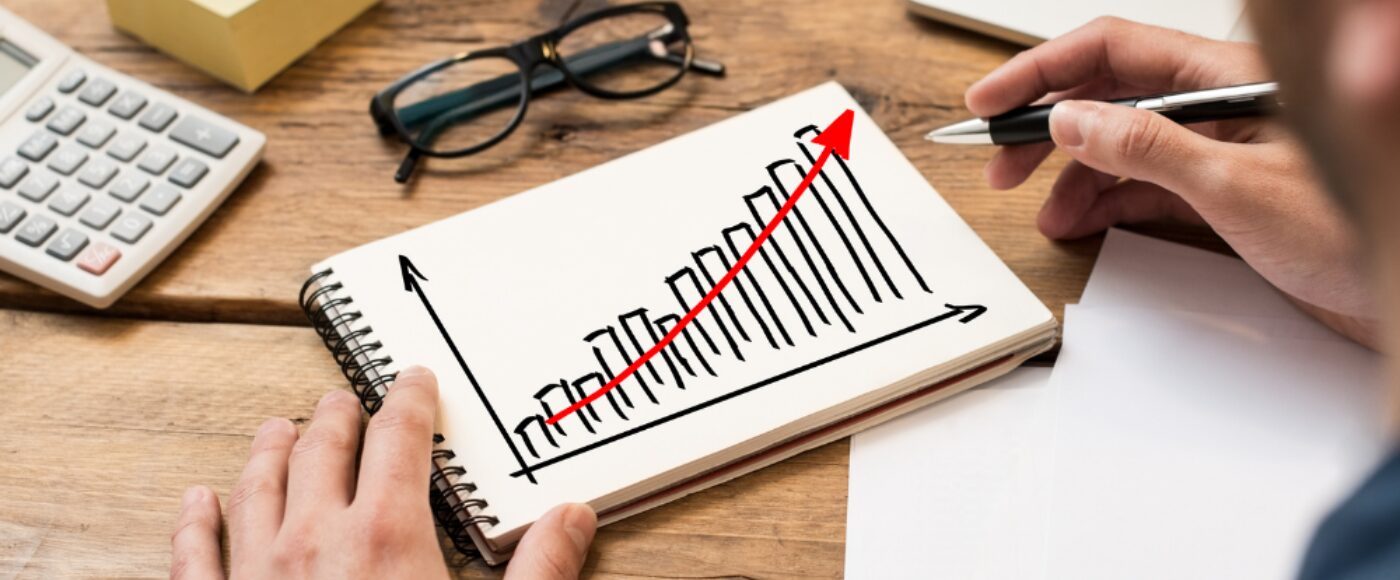 Businessman drawing a growing chart on a paper notebook