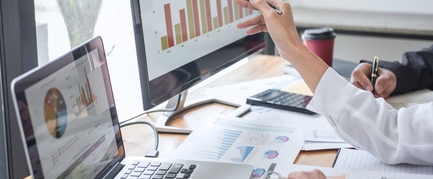 Business people looking at statistics on a computer screen.