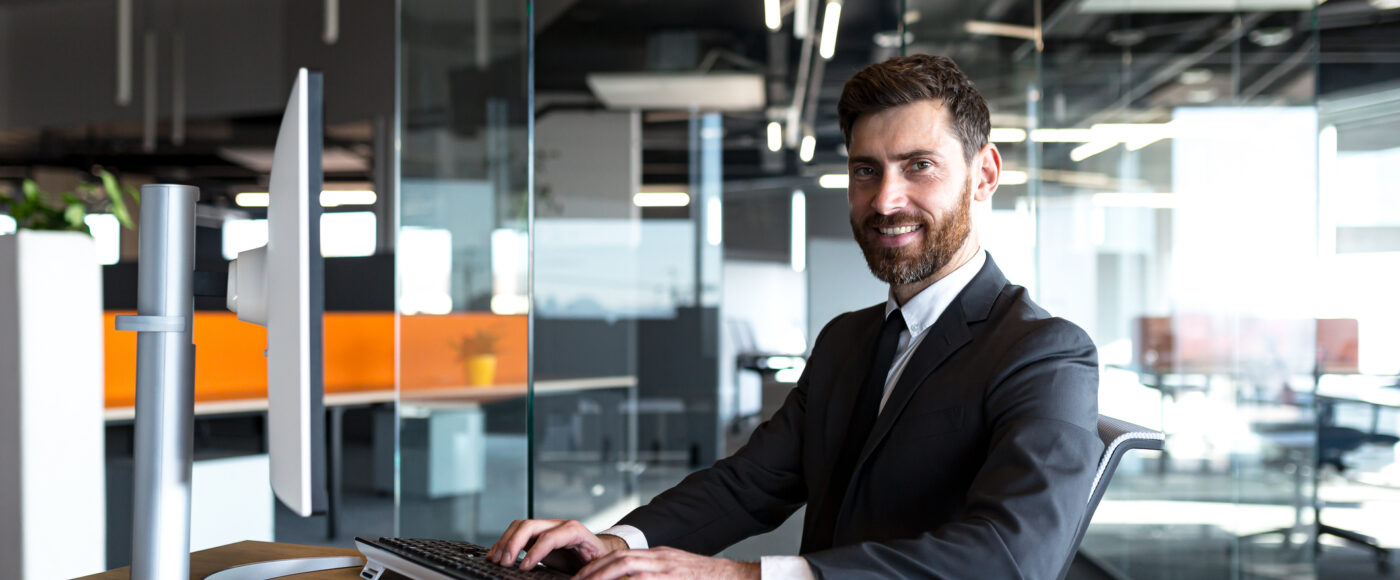 I Stock Business Explorer EXPLORE smiling business professional on laptop looking at camera