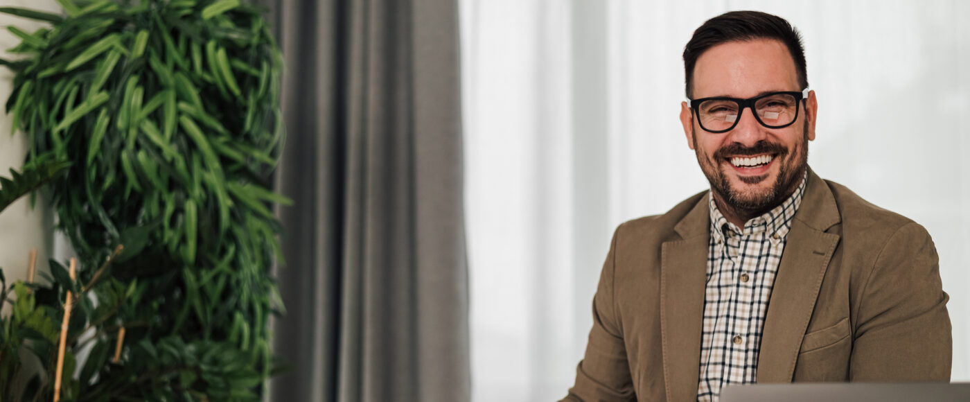 I Stock Business Explorer PLAN Smiling business profressional beside plant on laptop