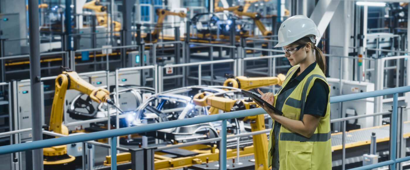 I Stock Innovation Boost technical factory worker in white hardhat operating a tablet