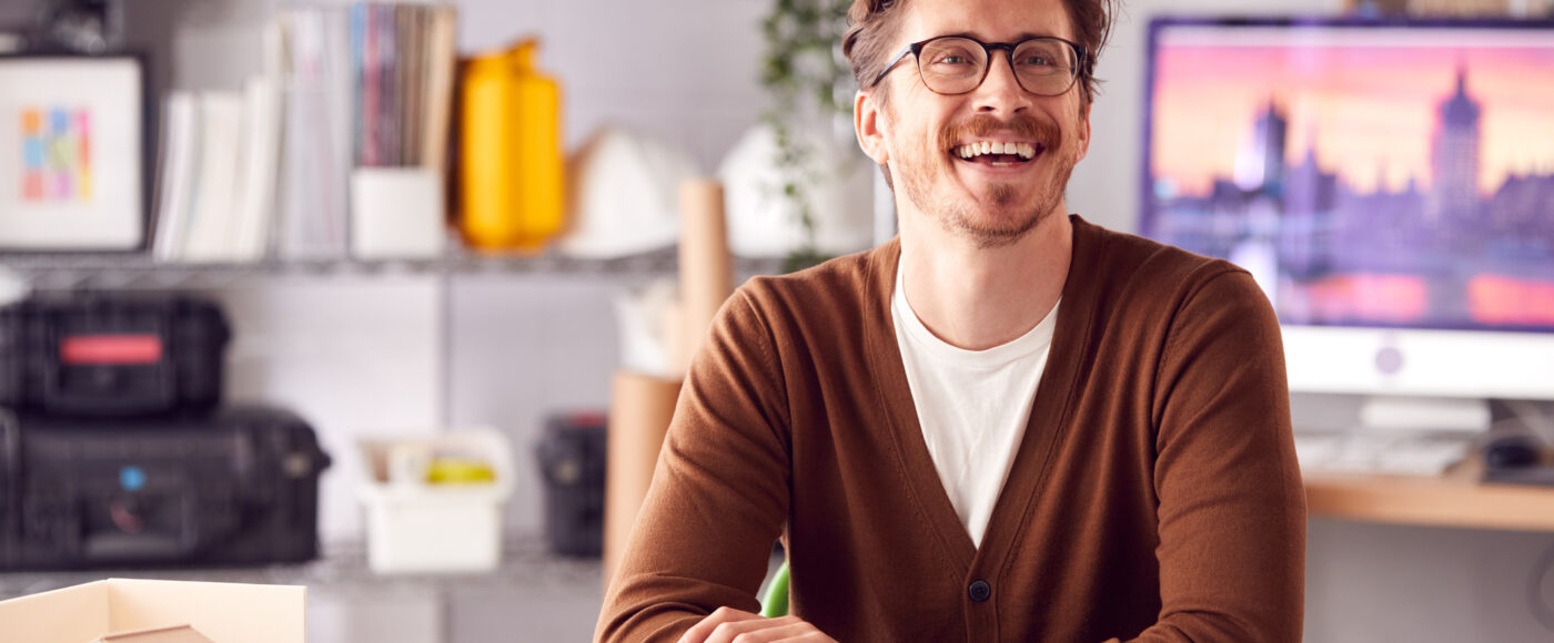 I Stock Synergy Smiling entrepreneur with dark coloured jumper clothing