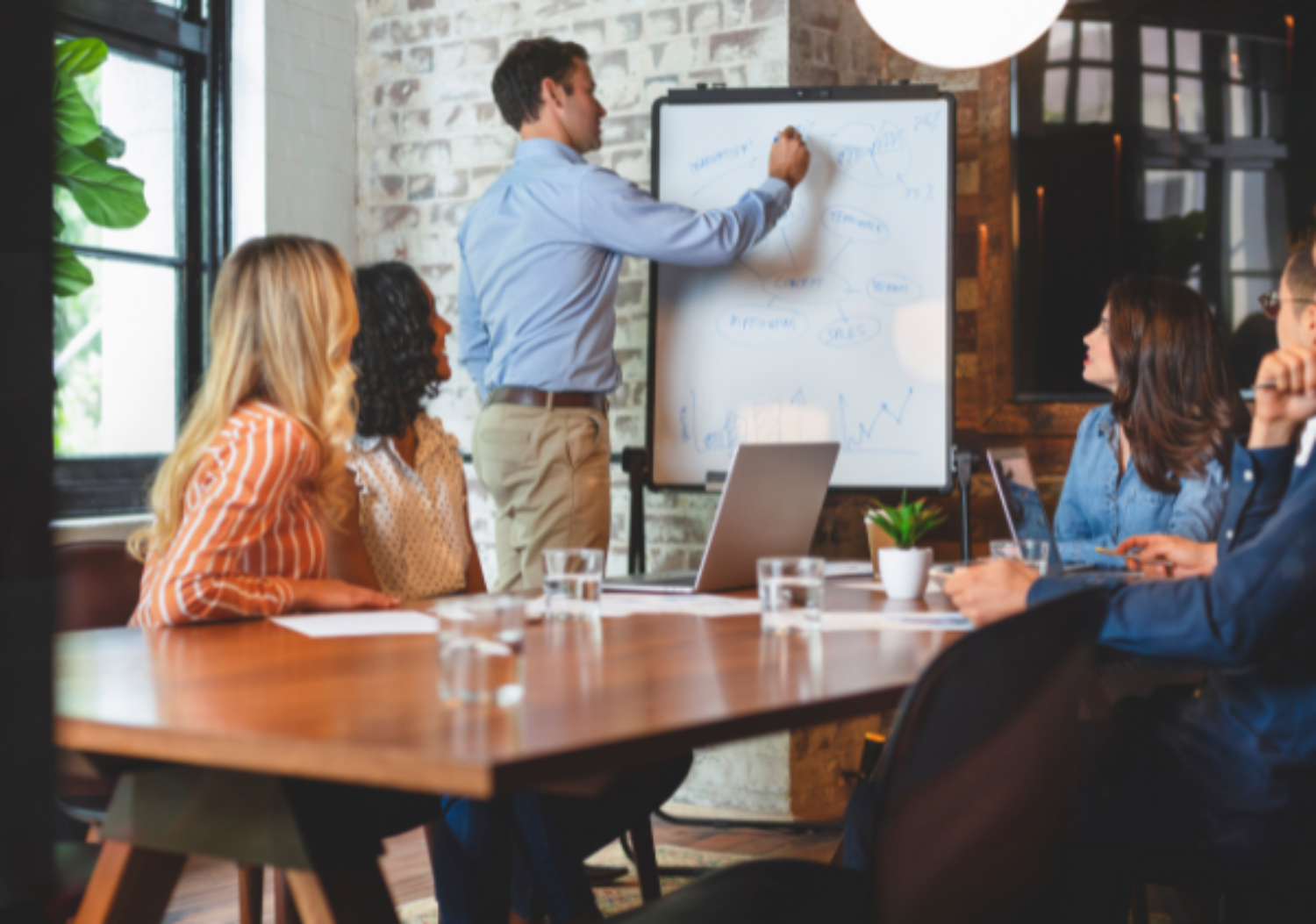Office full of people watching a business presentation
